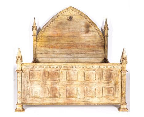 A limed oak and pine double bedstead in Gothic taste, modern; the crenellated arch backrest with pierced quatrefoil; flanked 