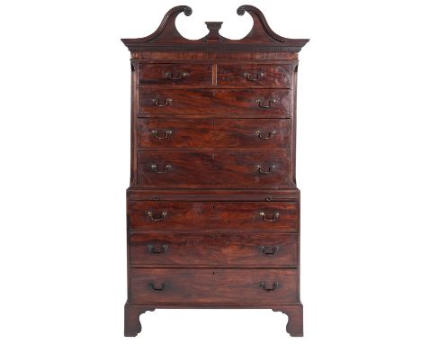 A George III mahogany chest on chest, late 18th century; with vacant dentilled plinth within a 'broken' swan-neck pediment, a