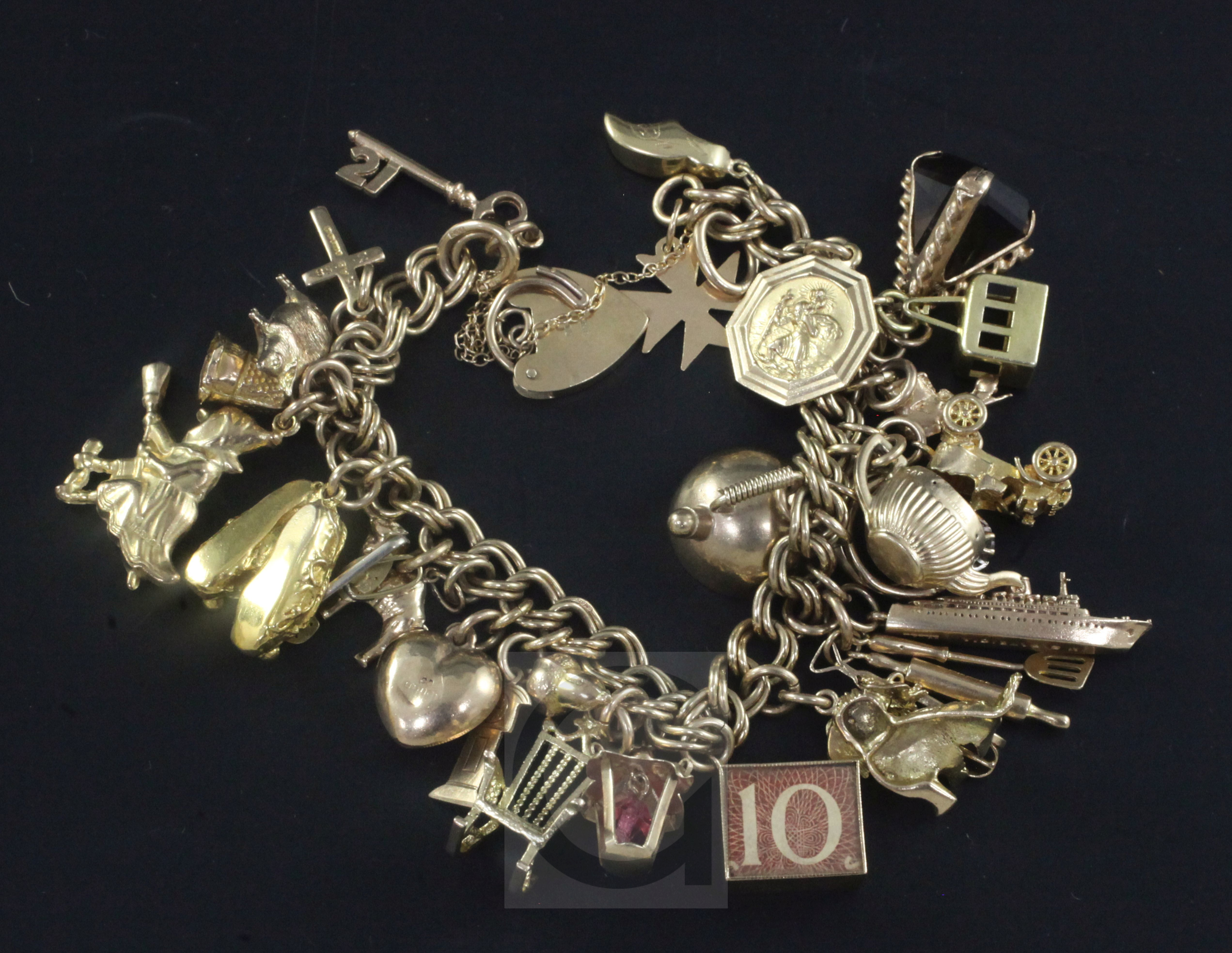 A 1960's 9ct gold charm bracelet, hung with twenty seven assorted