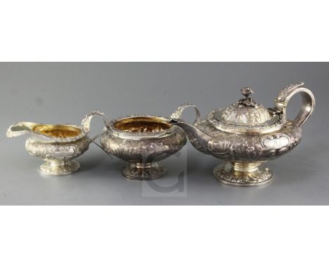 A George IV three piece embossed silver tea service of compressed melon form, William Hewitt? London 1824, gross 48 oz.