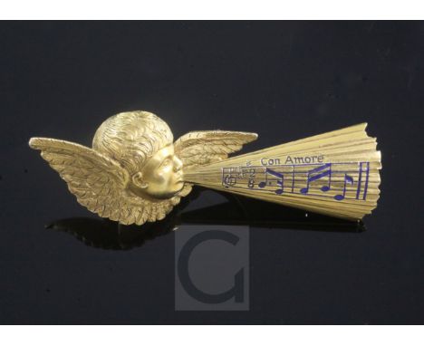 A late 19th century Tiffany & Co gold and enamel brooch, modelled as Cupid whistling musical notes and inscribed "Con Amore",