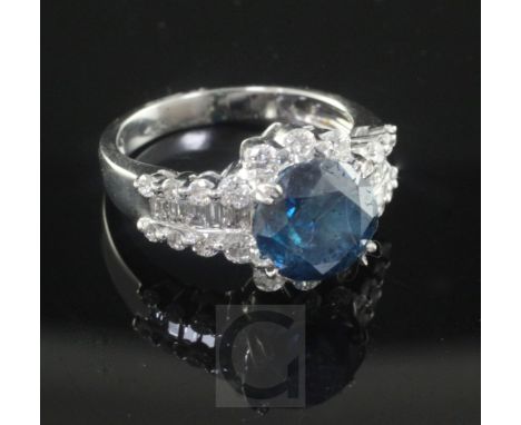 An 18ct white gold and single stone fancy colour diamond ring with round cut white diamond set border and baguette and round 