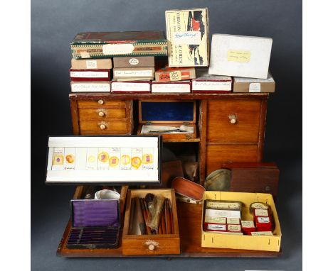 A Victorian stained pine work cabinet, containing various unused glass slides, test tubes, brushes, various tools and other i