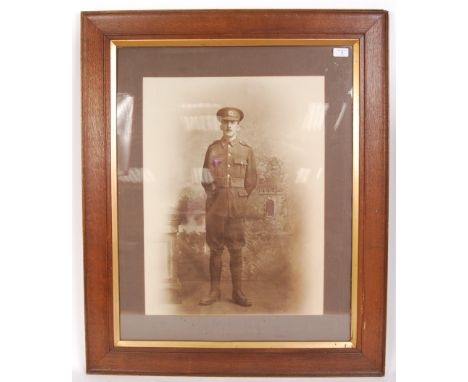 A large First World War WWI photograph of a soldier in battle dress. Framed and glazed in a period oak frame. Measuring appro