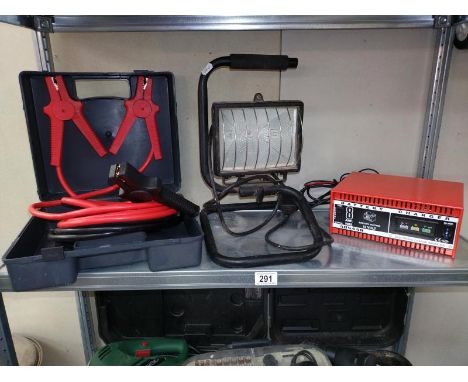 A boxed set of jump leads, work light and a ring battery charger.
