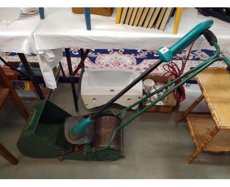 A Webb roller dust cylinder lawnmower and a Bosch Art strimmer.