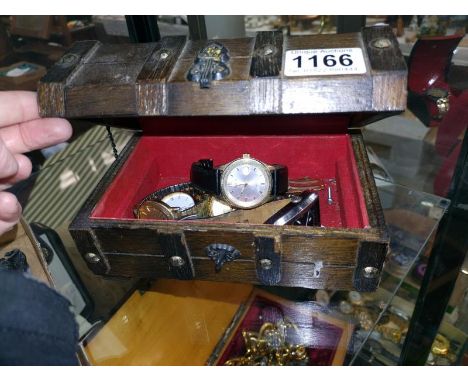 A quantity of wristwatches in a wooden trunk jewellery box.