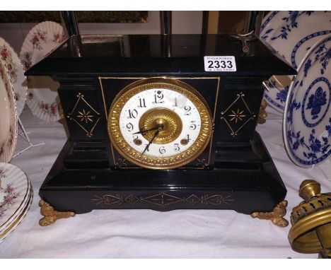 A Victorian black enamel mantel clock.