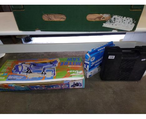 A boxed mitre saw, an electronic hot air gun and a cased battery drill. COLLECT ONLY.