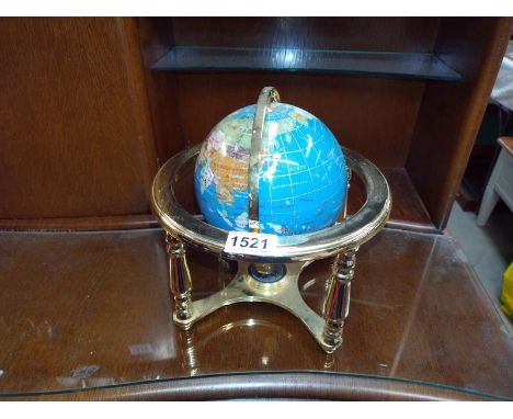 A stone globe on brass effect stand. 14cm diameter.