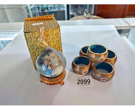 A Chinese reverse painting on glass ornament on stand and a set of five Cloisonne enamel napkin rings. 