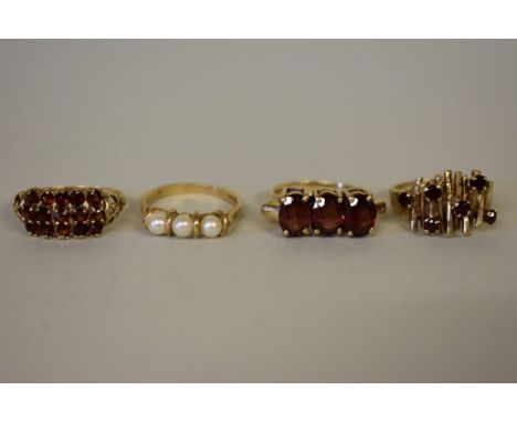 Three gold garnet rings;&nbsp;together with a pearl example, all&nbsp;hallmarked 375/9ct. 