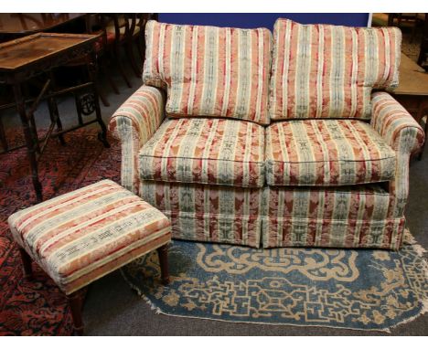 A Peter and Susan Brown two seater sofa, the cushioned back and seats in striped fabric, with roll arms and matching footstoo