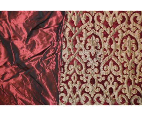 A pair of red and gold embroidered curtains, with foliate decoration, and a matching bed spread