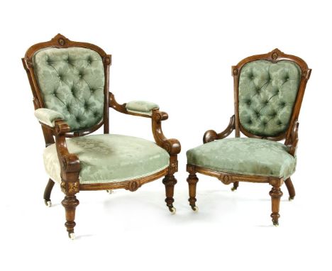 A pair of Victorian walnut and carved lady's and gentleman's chairs, upholstered in button back green silk damask pattern fab