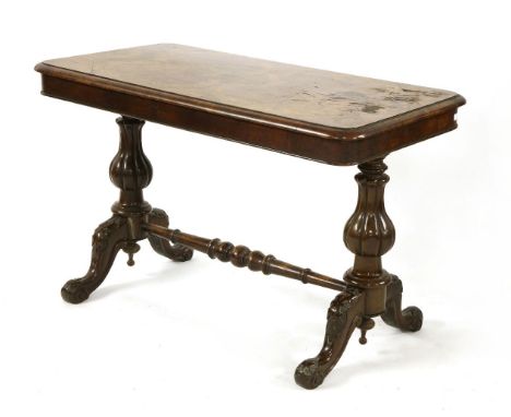 A Victorian walnut sofa table, the moulded rectangular top on carved end supports united by a stretcher, 104cm wide, 58cm dee