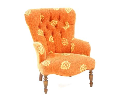 A Victorian design button back armchair, the shaped back above stuff over seat on turned supports