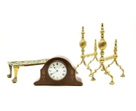 An Edwardian mantel clock, a pair of brass fire dogs and a trivet
