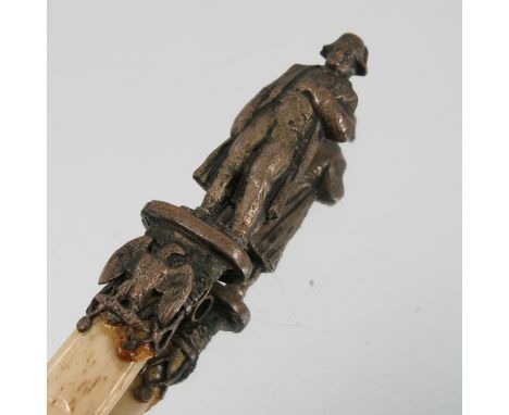 A gilt metal and bone book mark, the gilt metal terminal modelled as Napoleon, on an oval base with ring to the back and eagl