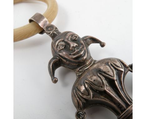 A silver babies' rattle, modelled as a jester, with ivory ring and mother of pearl teether, Birmingham 1905