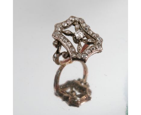 An Edwardian diamond panel ring, of open rectangular design enclosing a central diamond, with diamond set split shoulders, fi