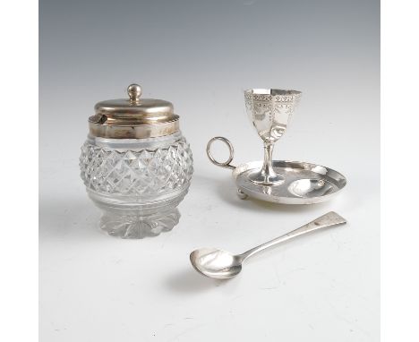 A silver egg cup, of octagonal form, with engraved decoration, mounted on a circular stand with spoons well and ring handle, 