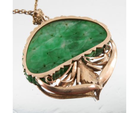 A carved jade pendant, the demi-lune shaped panel of a bird in foliage to a leaf mount, stamped '14k' to the bale, on a chain