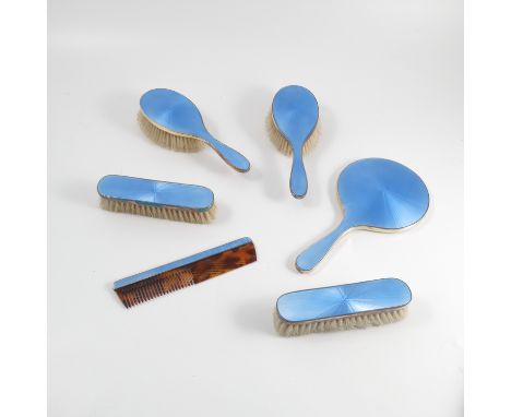 A boxed silver gilt and enamel dressing table set, comprising hand mirror, two pairs of brushes and a comb, decorated with bl