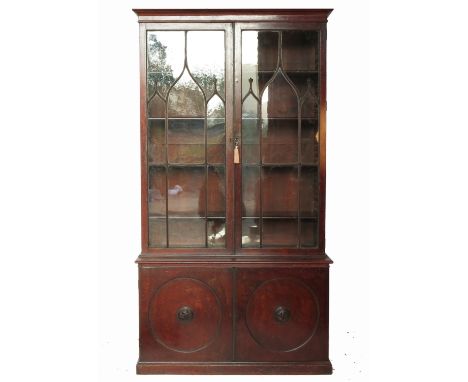 A 19th century mahogany bookcase, in the Pepys style, having glazed upper section with astragal glazing bars, with circular p