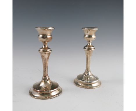 A pair of silver candlesticks, raised on circular bases, engraved FR June 24th 1934, af, height 6.75ins, together with a pair