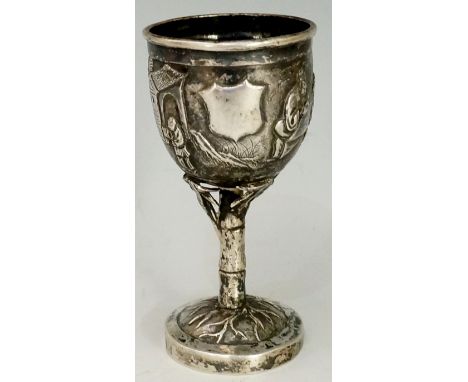 A Chinese silver coloured metal egg cup of miniature goblet form the urnular body with vacant shield shaped cartouche flanked