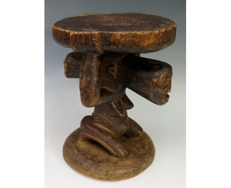 An African Congolese Chief's tribal trunk stool, the shaped circular top above a female kneeling figure, circular base, proba