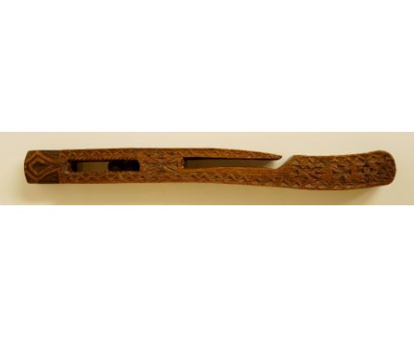 A Welsh knitting stick of rectangular outline carved overall with dog tooth borders and crosses, the chamfered finial above a