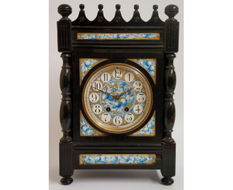 An English Arts & Crafts mantel clock, the ebonised case with arcaded sphere set pediment above fluted capitals and turned pi