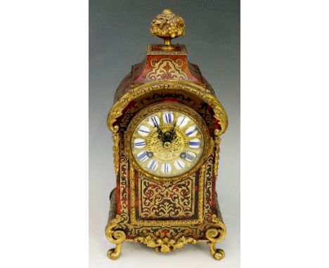 A 19th Century Boule mantel clock with urnular foliate finial the case inlaid in brass on a red tortoiseshell ground, the cir