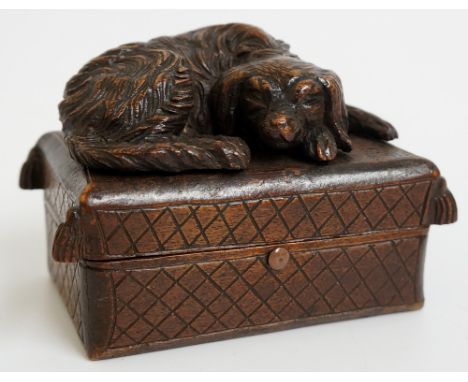 A Black Forest snuff box, the hinged lid carved with a dog sleeping on a tasseled cushion, 10.5cm wide, 7.5cm high max., late