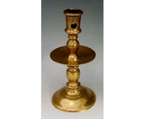 A 17th Century brass candlestick with broad drip pan, knopped base on shallow trumpet shaped base, 19cm high