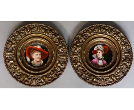 A pair of embossed brass plaques the borders with stylised griffins and oval cartouche the centres with ceramic plaques trans