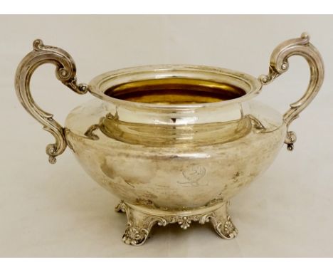 A Victorian large parcel-gilt sugar basin, shaped circular with S-scroll handles, the plain body engraved with a crest, on sh