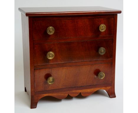 An early 19th Century miniature mahogany chest of drawers, the rectangular top above three long graduated figured drawers wit
