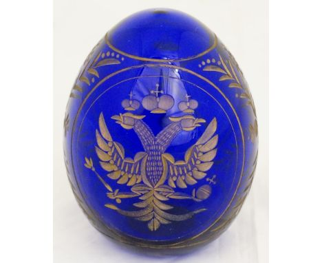 Fabergé - a blue glass egg, wheel engraved and gilt decorated with The Imperial Russian Eagle, the reverse with stylised flow
