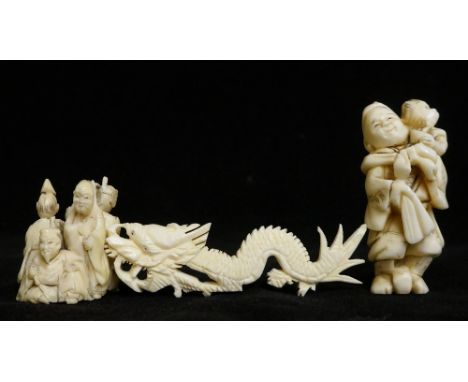 A Japanese carved ivory netsuke of a standing figure with monkey on his shoulders, 5.5cm high; a Japanese carved ivory group 