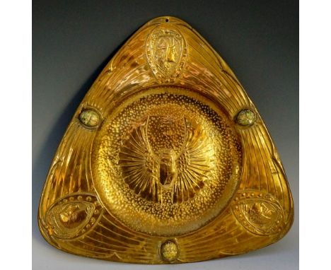 A late 19th Century brass faced pewter tray of triangular shape, embossed with three heads within oval frames the centre with