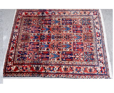 A Persian Bakhtiari carpet worked with five rows of seven varying designs in red and blue, guard stripes, fringed, 206cm x 10