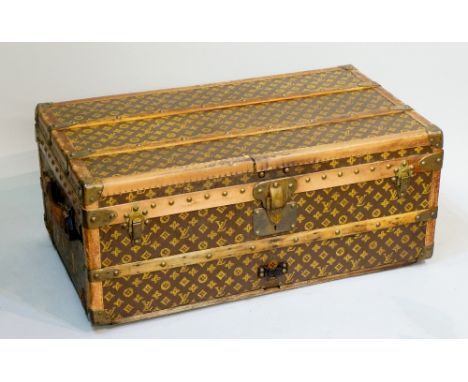 Louis Vuitton - a wooden brass and leather bound trunk, the body with LV fabric, the hinged lid revealing an interior, partit