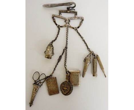 A Victorian silver chatelaine, the clip hung with three blue enamel silver "yolks" with belt suspension loops hung four curb 