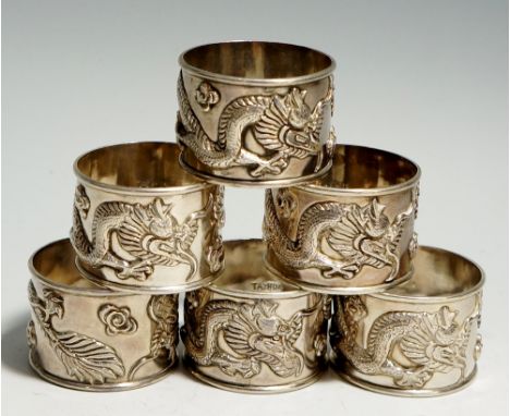 A set of six Chinese silver napkins rings, each chased with a stylised dragon and flowers, marked: Tai-Hua 康華 
