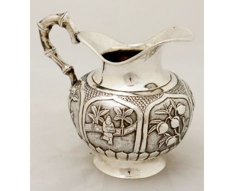 A Chinese silver coloured metal cream jug of compressed bulbous shape with plain neck and faux tapered bamboo handle, the bod