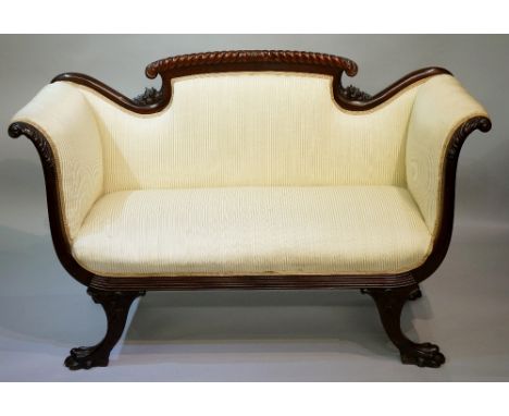 A compact Edwardian mahogany double scroll arm sofa the top rail rope and leaf carved with stylised cornucopia, the arms acan