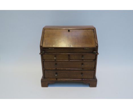 A 19th Century apprentice piece oak two small drawer over long drawers bureau fitted compartment, bracket feet. 28cm tall x 2